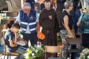 A friar pays his respects as he attends a funeral for the earthquake victims inside a gym in Ascoli Piceno