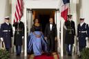 First lady Michelle Obama, left, and President Barack Obama wait for the arrival of French President François Hollande for a State Dinner at the North Portico of the White House on Tuesday, Feb. 11, 2014, in Washington. (AP Photo/ Evan Vucci)