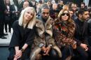From left, actress Noomi Rapace, singer Kanye West and fashion editor Carine Roitfeld attend the Givenchy men's Fall-Winter 2014-2015 fashion collection, presented Friday, Jan. 17, 2014 in Paris. (AP Photo/Zacharie Scheurer)