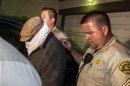Nakoula Basseley Nakoula is escorted out of his home by Los Angeles County Sheriff's officers in Cerritos, California
