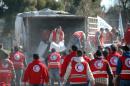 Syrian Arab Red Crescent workers offload aid from a lorry in the central Syrian city of Homs, on February 12, 2014