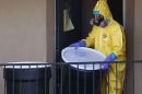 A worker in a hazardous material suit removes the contents of the apartment unit where a man diagnosed with the Ebola virus was staying in Dallas