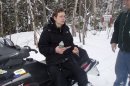 This photo released by the Maine Warden Service shows Nicholas Joy, 17, of Medford, Mass., sitting on a snowmobile Tuesday morning, March 5, 2013, after being found on a trail off the western side of Sugarloaf Mountain at Carrabassett Valley, Maine. Joy, who went missing Sunday during a family ski trip, survived two nights in the wild by building a snow cave for shelter, drinking water from a stream and walking toward the sound of snowmobiles during the day. (AP Photo/Maine Warden Service, Scott Thrasher)