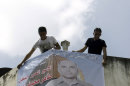 Relatives of Taher Zyoud hang a banner with his picture at his home in the West Bank village of Selat Al-Harithyah near Jenin, Monday, Aug. 12, 2013. Zyoud is one of the 26 Palestinian prisoners, most of them held for deadly attacks, Israel agreed to release this week as a part of a U.S.-brokered deal that led to a resumption of Mideast negotiations. Arabic reads, "He made me good, He let me out of prison" and "The hero released prisoner Taher Mohammed Zyoud welcome back to your home and to your family." (AP Photo/Mohammed Ballas)