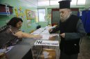 A Greek Orthodox priest casts his ballot at a polling station in Athens