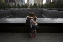 People embrace at the National September 11 Memorial and Museum in Lower Manhattan in New York
