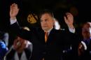 Hungarian Prime Minister Viktor Orban waves to supporters after winning the parliamentary election with members of his FIDESZ party on April 6, 2014 in Budapest