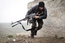 In this Monday, Dec. 17, 2012 photo, a Free Syrian Army fighter takes cover during fighting with the Syrian Army in Azaz, Syria. (AP Photo/Virginie Nguyen Huang)