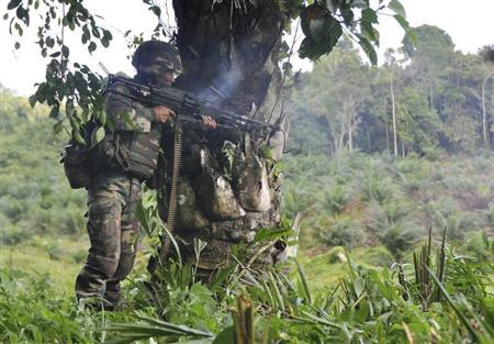 A Malaysian soldier uses a weapon in the area of Sungai Nyamuk, a village adjacent to Kampung Tanduo where troops stormed the camp of an armed Filipino group, in Lahad Datu, Sabah state, March 12, 2013 in this picture provided by Malaysia's Ministry of Defence. REUTERS/Malaysia's Ministry of Defence/Handout