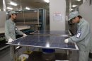 Employees work on a solar panel production line at Suntech Power Holdings headquarters in Wuxi