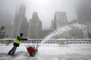 A worker pushes a snow plough to clear a path during blizzard conditions in Chicago