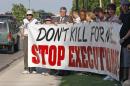 Death penalty opponents hold a sign outside the Governor's Mansion in Oklahoma City, Tuesday, May 1, 2012, to protest the execution of Michael Bascum Selsor. An Oklahoma man convicted of murdering a Tulsa convenience store manager almost 37 years ago was executed by lethal injection Tuesday. (AP Photo/Sue Ogrocki)