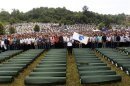 Bosnians pray in front of 409 coffins of newly identified victims of the 1995 Srebrenica massacre in the Potocari Memorial Center, near Srebrenica