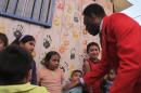 Brazilian soccer legend Pele puts out his hand, while greeting children in a visit to a slum in Santiago, Chile, Thursday, April 9, 2015. The activity was organized Thursday by a local NGO and a bank, seeking to inspire Chilean children. Pele says he has "happily recovered" from a recent health scare. (AP Photo/Luis Andres Henao)