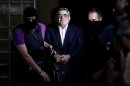 The leader of ultra-right wing Golden Dawn party Nikos Michaloliakos is escorted by masked police officers to the prosecutor from the police headquarters in Athens on September 28, 2013