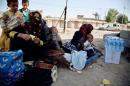 Mothers sit with their children at Dibis checkpoint near the Iraqi city of Kirkuk, Iraq