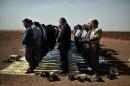Syrian and Turkish Kurds pray during the Friday prayer at the Turkish-Syrian border opposite the Syrian town of Ain al-Arab, known as Kobane by the Kurds, on October 10, 2014