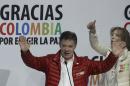 Colombia's President Juan Manuel Santos speaks at his campaign headquarters in Bogota, Colombia, Sunday, May 25, 2014. Santos finished second in the opening round of the presidential election and will face winner Oscar Ivan Zuluaga, of the Democratic Center, in a runoff on June 15. At right first lady Maria Clemencia Rodriguez. (AP Photo/Javier Galeano)