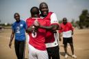 International Liberian soccer star and presidential hopeful George Weah embraces a team member at the end of a match played in Monrovia, Liberia on April 30, 2016