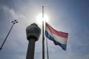 A flag flies half-staff near the traffic tower at Schiphol airport in Amsterdam, Friday, July 18, 2014. The attack on a Malaysian jetliner Thursday afternoon killed 298 people from nearly a dozen nations, more than half being Dutch, including vacationers, students and a large contingent of scientists heading to an AIDS conference in Australia. (AP Photo/Phil Nijhuis)