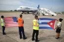 Ground crew hold U.S. and Cuban flags near a recently landed JetBlue aeroplane at the Abel Santamaria International Airport in Santa Clara, Cuba