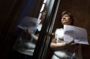 Luz Maria Reyes Coral, 52, is seen at the main entrance of her home as she waits to be evicted in Madrid, Spain, Wednesday, May 30, 2012. The recently nationalized Bankia bank claims Reyes owes them 196.000 euros (US$244.000). Last week, Bankia, Spain's fourth-largest bank announced it would need a further euro 19 billion (US$23.88 billion) in state aid to shore up its defenses against losses from its toxic loans. Activists from the 'Stop Evictions' platform successfully stopped the eviction. (AP Photo/Alberto Di Lolli)
