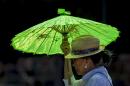 A pedestrian shields under a parasol from the hot sun in the Echo Park district in Los Angeles Wednesday, May, 14, 2014. A heat wave gripped California compounding the critical drought conditions across the state. (AP Photo)