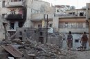 Men walk past destruction in Bab-Todmor in Homs