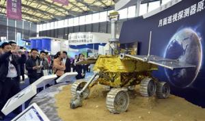 Visitors take pictures of a prototype model of a lunar rover at the 15th China International Industry Fair in Shanghai