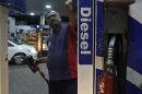A worker switches on a fuel pump before filling a car with diesel at a fuel station in New Delhi