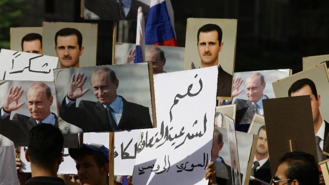 Several hundred people, holding up portraits of Syrian President Bashar al-Assad and his Russian counterpart Vladimir Putin (L), gather near the Russian embassy in Damascus on October 13, 2015