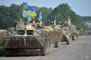 Ukrainian servicemen sitting atop armored personnel carriers (APC) travel near the eastern Ukrainian city of Slavyansk on July 11, 2014