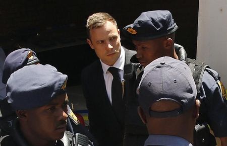 South African Olympic and Paralympic sprinter Oscar Pistorius (C) is escorted to a police van after his sentencing at the North Gauteng High Court in Pretoria October 21, 2014.  REUTERS/Siphiwe Sibeko