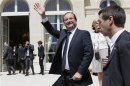 France's President Francois Hollande waves to visitors in the gardens of the Elysee Palace in Paris