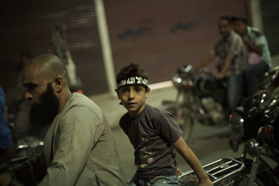 An Egyptian Muslim child rides on the back of a motorbike during a rally supporting former President Mohammed Morsi in Assiut, Upper Egypt, Tuesday, Aug. 6, 2013. Islamists may be on the defensive in Cairo, but in Egypt's deep south they still have much sway and audacity: over the past week, they have stepped up a hate campaign against the area's Christians. Blaming the broader Coptic community for the July 3 coup that removed Islamist President Mohammed Morsi, Islamists have marked Christian homes, stores and churches with crosses and threatening graffiti. (AP Photo/Manu Brabo)