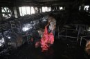 A garment worker inspects a factory belonging to Tung Hai Group, a large garment exporter, after a fire in Dhaka.