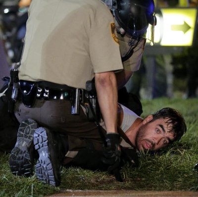 A man is detained by police during a protest Monday, Aug. 18, 2014, for Michael Brown, who was killed by a police officer Aug. 9 in Ferguson, Mo. Brown's shooting has sparked more than a week of protests, riots and looting in the St. Louis suburb. (AP Photo/Charlie Riedel)