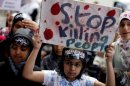 A protester holds up a sign during a demonstration outside the Syrian embassy in London