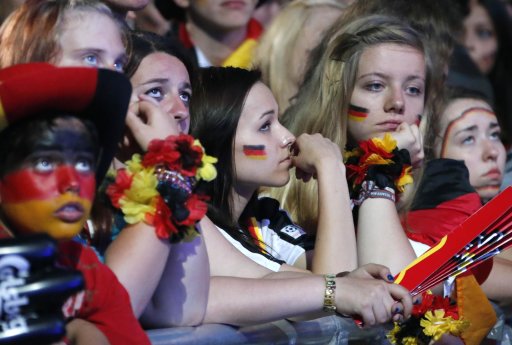 German soccer fans react during a public screening, while they watch their team play against Italy in their Euro 2012 semi-final soccer match, in Berlin