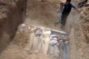 Syrians cover a mass grave of people who rebels claim were killed in a toxic gas attack, August 21, 2013