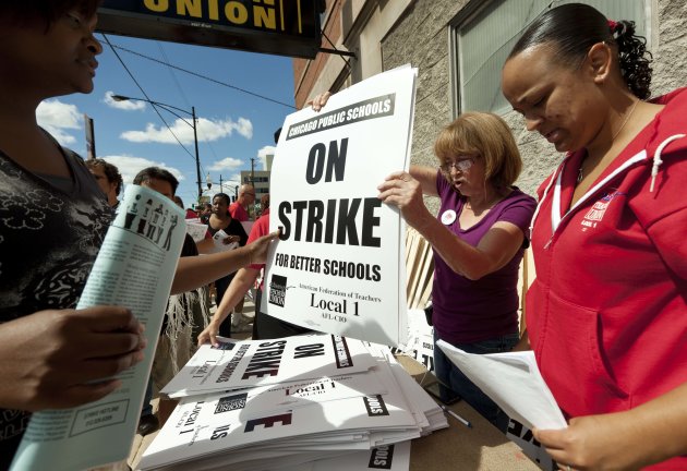 FILE - In this Saturday, Sept. 8, 2012 file photo, members of the Chicago Teachers Union distribute strike signage at the Chicago Teachers Union strike headquarters in Chicago. The Chicago Teachers Union announced Sunday night that its 25,000 members will go on strike Monday morning, Sept. 10, 2012, for the first time in 25 years after contract talks with the school district failed over issues that included benefits and job security. (AP Photo/Sitthixay Ditthavong)