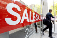 In this Wednesday, Sept. 18, 2013 photo, a consumer exits a store with a sale sign posted in the windows in Philadelphia. The government reports how much consumers spent and earned in August on Friday, Sept. 27, 2013. (AP Photo/Matt Rourke)