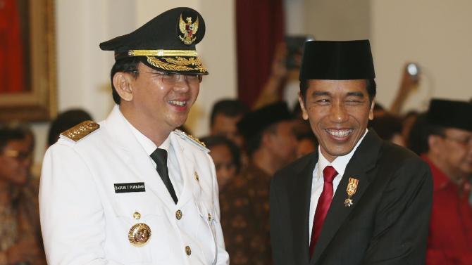 Basuki Tjahaja Purnama, left, is congratulated by Indonesian President Joko Widodo after taking the oath of office to become the governor of Indonesia&#39;s capital Jakarta, Wednesday, Nov. 19, 2014. Purnama, a Christian, was sworn in despite protests from Islamic hardliners who insist the job should be reserved for a Muslim in the city of 12 million people. (AP Photo/Tatan Syuflana)