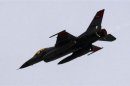 An Egyptian Air Force F-16 fighter jet flies low over thousands of anti-government protesters gathered at Tahrir square in Cairo