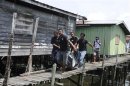 Villagers carry body of a dead gunmen that was killed on Saturday for removal at Simunul village in Sabah's Semporna district