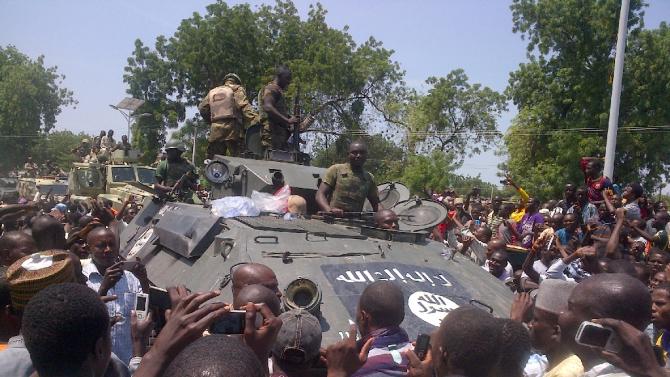 Maiduguri residents welcome troops who recovered an armored personnel carrier (APC) from Boko Haram insurgents in Konduga on September 16, 2014