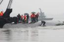 A diver (C) walks into the water as rescue teams search for survivors from the Dongfangzhixing or "Eastern Star" vessel which sank in the Yangtze river on June 2, 2015
