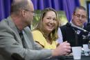 Amy Riddering, center, widow of Michael Riddering, an American missionary, killed by al-Qaida fighters in Africa last month, smiles as her brother-in-law Jeff Riddering relates a story about him during a news conference at the Hollywood Community Church, Friday, Feb. 5, 2016, in Hollywood, Fla. Amy Riddering said Friday that she will return this month to Burkina Faso and the orphanage and women's center she ran with her husband. She said she believes that is God's plan for her. At right is Pastor Brian Burkholder. (AP Photo/Wilfredo Lee)