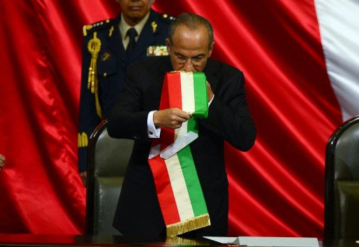 Saliente presidente de México Felipe Calderón besa la banda presidencial previo al juramento de su sucesor Enriqeu Peña Nieto del PRI en Ciudad de México el 1 de diciembre de 2012. (AFP | alfredo estrella)