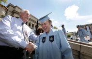 Columbia University janitor Gac Filipaj, center, is congratulated by his boss, Donald Schlosser, the assistant vice president of facility operations, during the Columbia University School of General Studies graduation, Sunday, May 13, 2012, in New York. Filipaj, an ethnic Albanian who left his native Montenegro 20 years ago to escape war, is graduating with honors after 12 years of balancing studies and his full-time job. (AP Photo/Jason DeCrow)